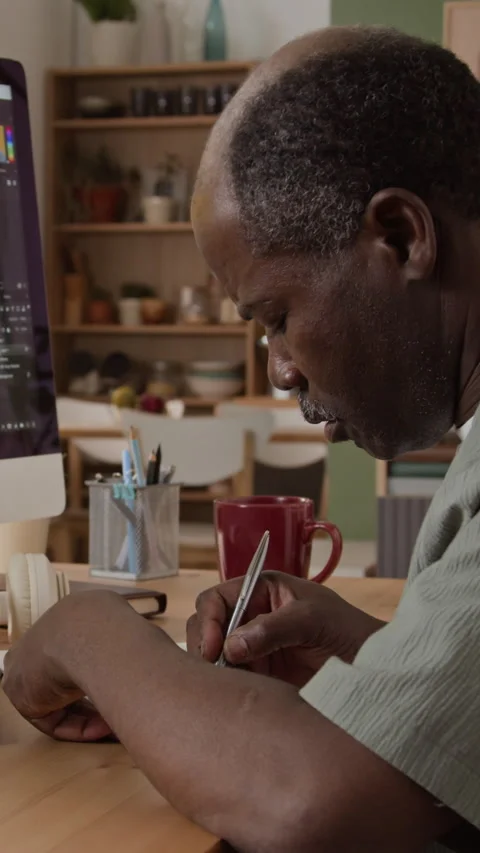 Mature Black Man Writing Notes While Working on Computer Stock Footage 347654060