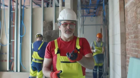 Mature builder adjusting laser level on construction site Stock Footage 133638445