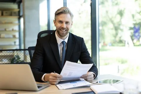 Mature businessman with beard working with documents, contracts and bills s.. Stock Photos
