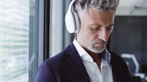 Mature businessman with earphones. Stock Footage