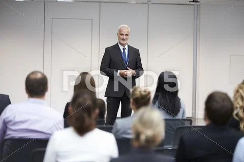 Mature Businessman Making Presentation At Conference