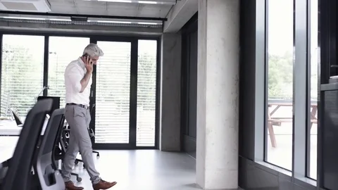 Mature businessman with smartphone in the office. Stock Footage