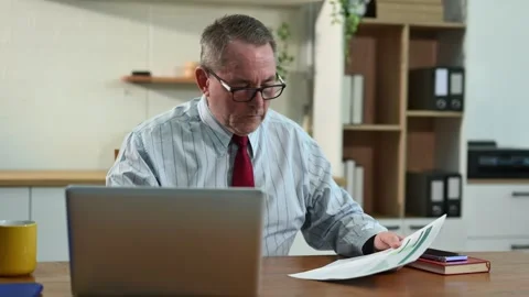 Mature Businessman using laptop while sitting at home. man sitting in kitch.. Stock Footage 313460712