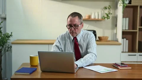 Mature Businessman using laptop while sitting at home. man sitting in kitch.. Stock Footage 313460715