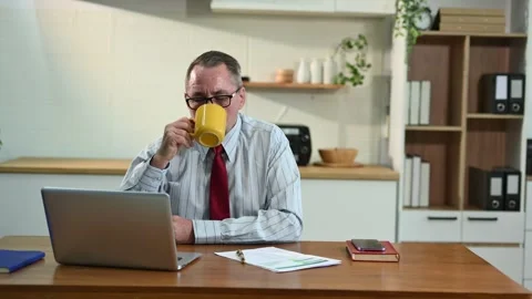 Mature Businessman using laptop while sitting at home. man sitting in kitch.. Stock Footage 313460721