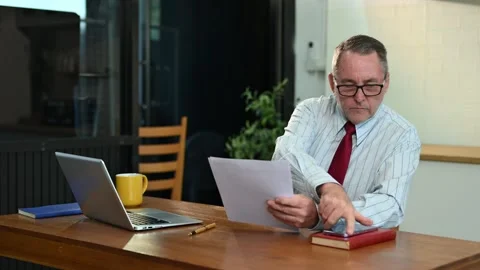 Mature Businessman using laptop while sitting at home. man sitting in kitch.. Stock Footage 313460723