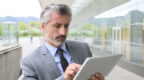 Mature businessman using tablet outside building Stock-Footage 49761541