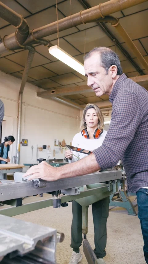 Mature carpentry instructor teaching students in a workshop Stock Footage 340170387