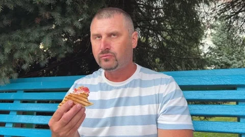 A mature Caucasian man eats fast food, a tortilla with meat and vegetables on Stock Footage 282146715