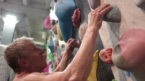 Mature Caucasian man has climbing workout at indoor rock gym Stock Footage