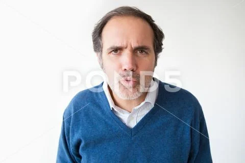 Mature Caucasian man pouting lips and looking at camera Stock Photos