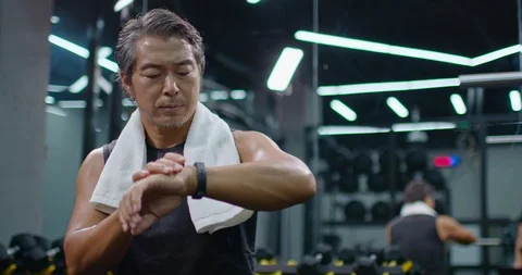 Mature Chinese man checking smart watch at gym,4K Stock Footage 120766522