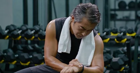 Mature Chinese man checking smart watch at gym,4K Stock Footage 120766967