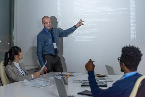 Mature coach pointing at interactive whiteboard Stock Photos