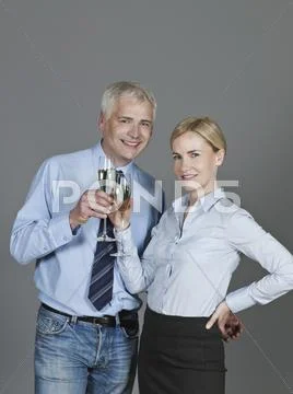 Mature couple drinking sparkling wine, smiling, portrait Stock Photos