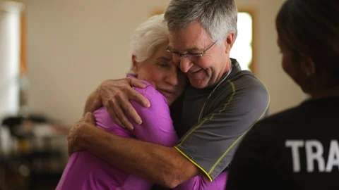 Mature couple hug while talking to their personal trainer. Vidéo 88367815