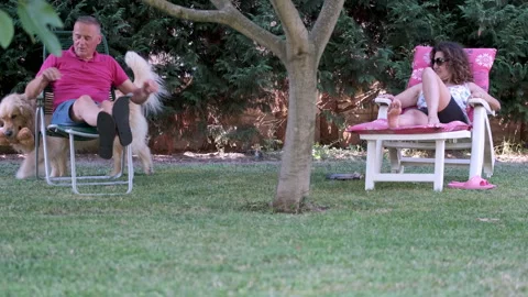 Mature couple lying on deck chairs together with their dog. Stock-Footage 245986134
