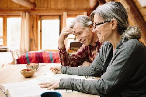 Mature couple with map at cabin table Stock Photos