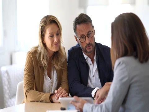 Mature couple meeting real-estate agent in office Stock Footage
