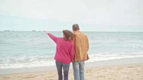 Mature couple in path to the beach pointing at sea Stock Footage 272447338