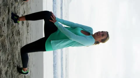 Mature couple performing stretching exercise on beach Vídeos de archivo 300650183