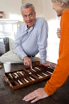 Mature couple playing backgammon Stock Photos