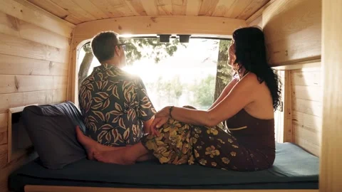 Mature couple relaxing inside camper van enjoying sunset view Stock Footage 344824337