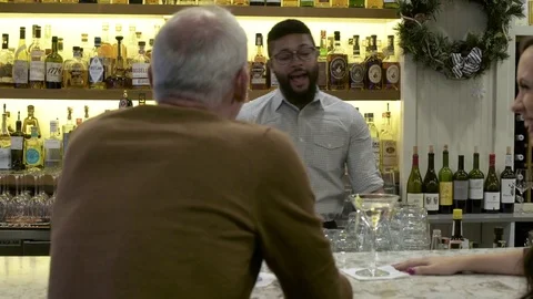 Mature couple talking with a bartender 動画素材 75209404