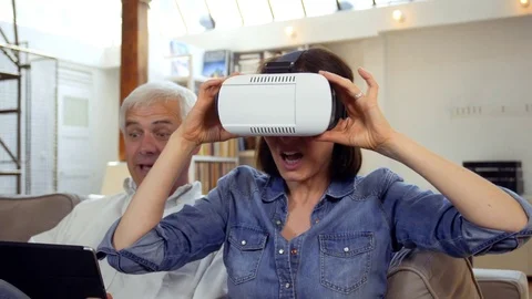 Mature couple using virtual reality headset in living room Video stock 81247850