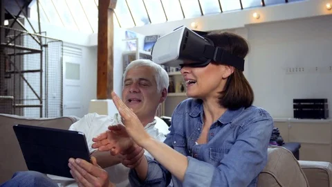 Mature couple using virtual reality headset in living room Video stock 81247885