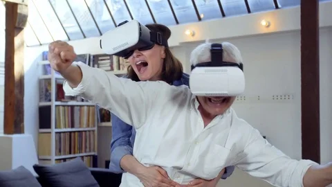 Mature couple using virtual reality headset in living room Video stock 81248042