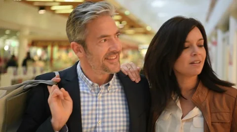 Mature couple walking in shopping mall Stock Footage
