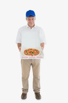 Mature delivery man looking at fresh pizza Stock Photos