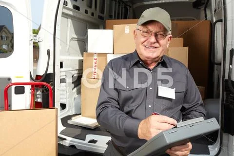 Mature delivery man with a parcel. Stock Photos