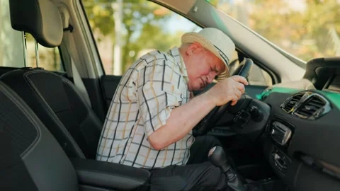 Mature driver experiencing a sudden heart attack behind the steering wheel. Stock Footage 343263966