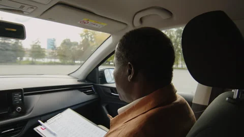 Mature Driving Instructor Sitting in Passenger Seat, Directing Learner Stock Footage 276544864