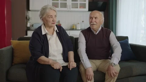 Mature elderly couple sitting on sofa in living room. Stock Footage 190677538