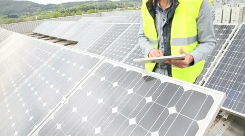 Mature engineer on building roof checking solar panels Video stock 49760255