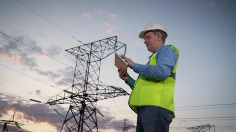 Mature engineer controls maintenance of power transmission lines via tablet Stock Footage 256065973