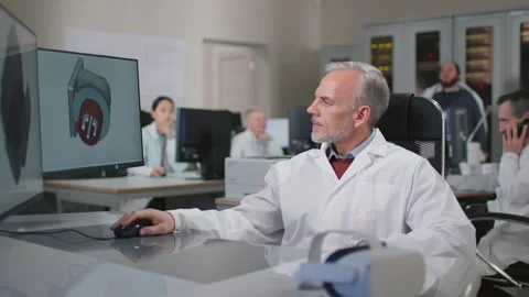 Mature engineer in lab coat work on computer designing 3d model Stock Footage 243632242