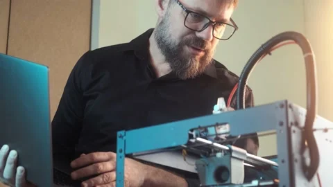Mature engineer man using a 3D printer at home office workplace Stock Footage 237078646