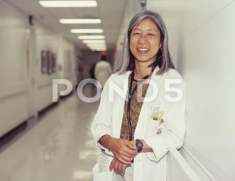 Mature female doctor in hospital hallway Stock Photos