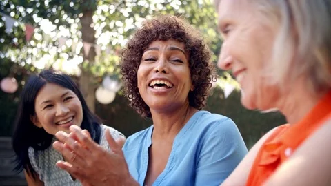 Mature Female Friends Socializing In Backyard Together Stock Footage