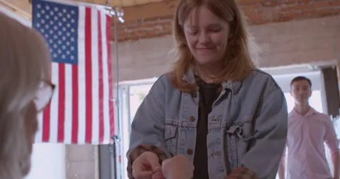 Mature female poll worker processing voters with a digital tablet Stock Footage 274982369
