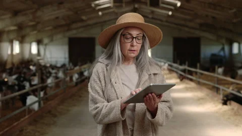 Mature female worker using tablet while walking at goat farm Stock Footage 157585942