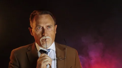 Mature gentleman on dark background Stock Footage 129257895