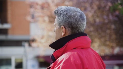 Mature gray-Haired Man in a red jacket turns his face Stock-Footage 100945925