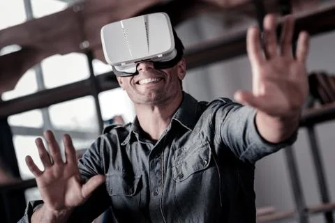 Mature guy smiling cheerfully while wearing vr headset Stock Photos