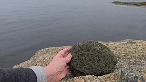 Mature hand carefully building a balancing stone tower. Stock Footage 341355441