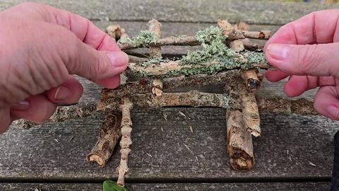 Mature hands building a small pyramid from natural branches Stock Footage 344818995